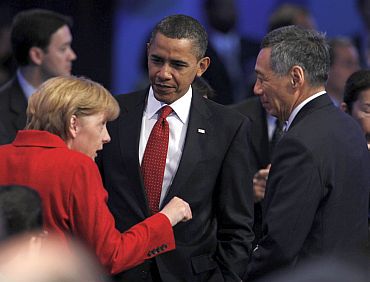 US President Obama listens to German Chancellor Merkel alongside Singapore's PM Lee