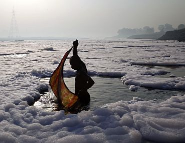 A devotee wraps his cloth after a ritual dip in the polluted Yamuna river in New Delhi