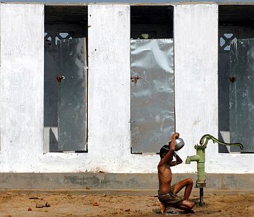 A boy takes bath under a tubewell in a village on the outskirts of Nagapattinam