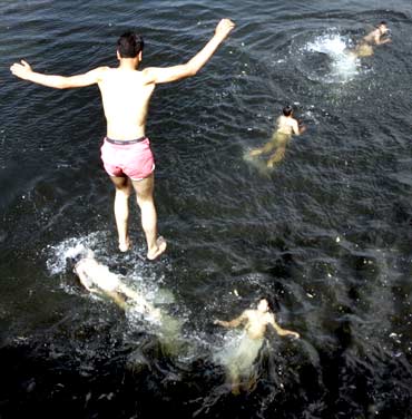 A boy jumps into a lake to beat the heat