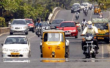 Vehicles move through a mirage of heat in Hyderabad
