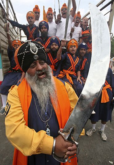 'Nihangs' or Sikh warriors hold swords and shout slogans during a religious procession ahead of the Baisakhi festival in Chandigarh