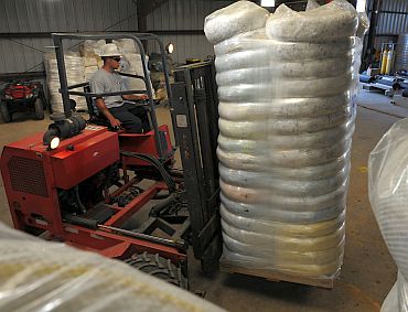 reston Kott of US Environmental Services moves oil absorbent boom into a warehouse at a pollution control staging area