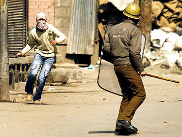 A policeman confronts a stone throwing Kashmiri protester in Srinagar, February 20