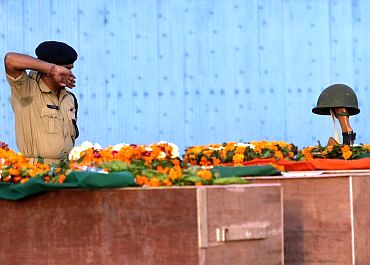 A CRPF jawan pays his last respects to colleagues who died in a Naxalite attack in Chhattisgarh
