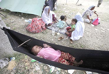 A child lay crying in a hammock after flood victims shifted to camps to take refuge after their homes were destroyed in Nowshera on August 3