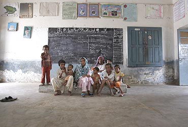 A family living near the Sindh river took shelter in a class room in Sukkur, in Pakistan's Sindh province, on August 3
