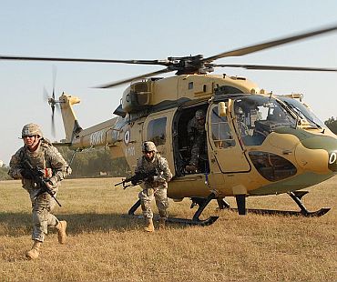 US Army soldiers exit an Indian army HAL Dhruv advanced light helicopter from the 201st Army Aviation Squadron during static load training on Camp Bundela, India