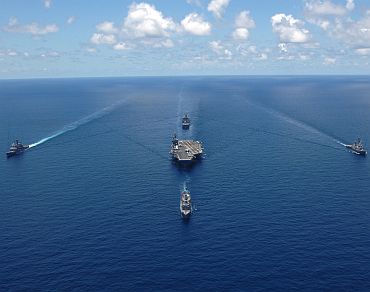 US Navy ships assigned to the USS George Washington Carrier Strike Group sail in formation