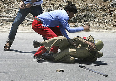 A protester hits a policeman during a protest march