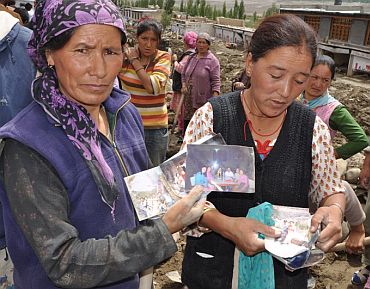 Ladakhi women show photographs of missing relatives in the hope they will be found some day