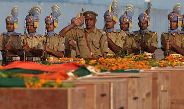 CRPF personnel in New Delhi pay their last respects near the coffins of policemen who died in a Maoist attack in Dantewada