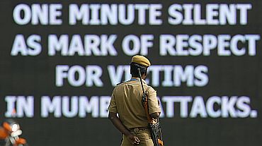 A policeman looks at a message displayed on digital screen during one minute silence for victims of the 26/11 Mumbai attacks