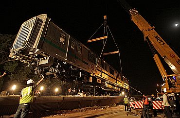 A Delhi Metro rail carriage is lifted on to a track for the trial runs of a new line in New Delhi on June 27, 2010