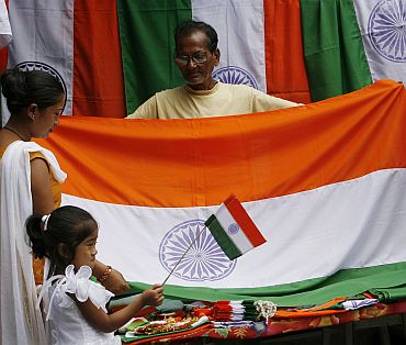 A vender sells Indian national flags to his customers at a shop in Siliguri.