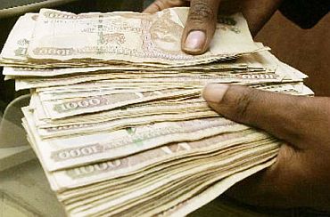 A Kenyan bank staff counts currency