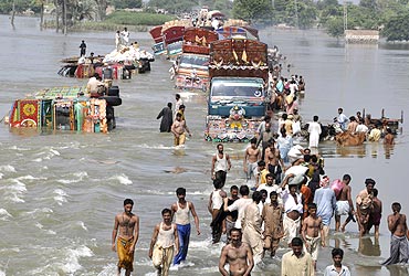 Locals cross a flooded road in Pakistan