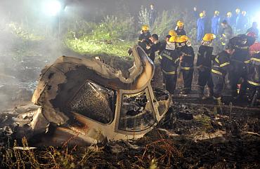 Rescuers check the wreckage of a crashed passenger plane in Yichun, northeast China's Heilongjiang province August 24, 2010