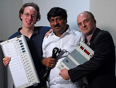 EVM report authors (left to right) J Alex Halderman, Hari K Prasad, and Rop Gonggrijp holding the EVM that they hacked into