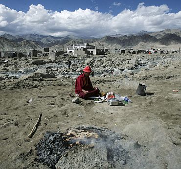 A monk performs religious rites for flash floods victims on the outskirts of Leh
