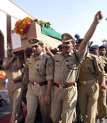 Security personnel carry a coffin of a policeman killed in a Maoist attack in Chhattisgarh