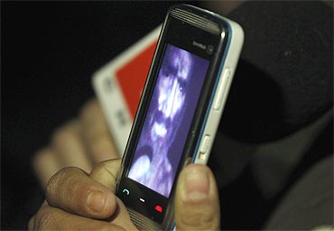 A relative of one of the miners trapped underground in a copper and gold mine, shows a video of a miner on her mobile phone that was recorded from inside the mine in Copiapo