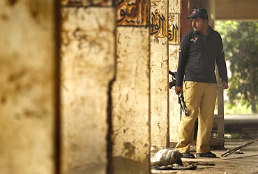 A policeman inspects the flood destroyed police headquarters in Nowshera