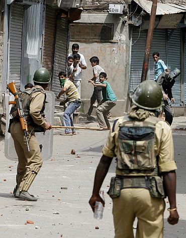 Kashmiri protesters throw stones towards policemen during a protest in Srinagar