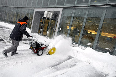 A man clears the snow away from the front of a business centre in Warsaw