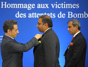 Sarkozy awards Director of the Taj Mahal Palace Karambir Kang (C) and Oberoi Hotel Vice President Devendra Bharma (R) during a ceremony in remembrance of the victims of the November 2008 attacks