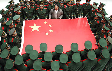 Paramilitary soldiers hold the Chinese national flag during a photo session at an army base in Taizhou, Zhejiang province