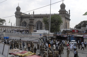 Policemen stand guard at the site of a bomb blast at Mecca Masjid