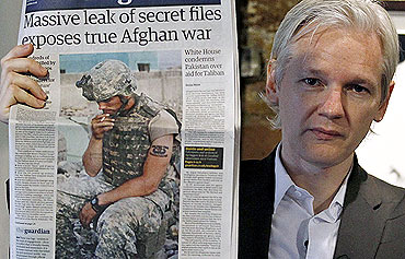 Wikileaks founder Julian Assange holds up a copy of a newspaper during a press conference at the Frontline Club in central London