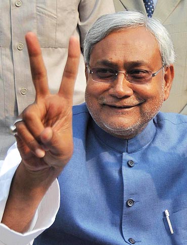 Bihar Chief Minister Nitish Kumar flashes a V-sign during a news conference in Patna after a thumping victory in state assembly polls