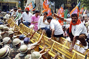 BJP activists face police try to stop them during a protest against the 2G scam