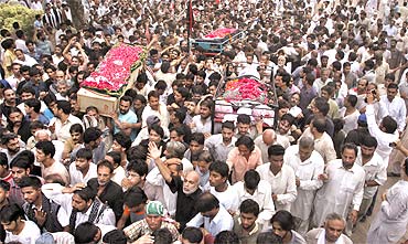 Men carry coffins of victims who were killed in a bomb blast in Lahore