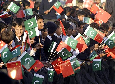 Pakistani school children hold Pakistani and Chinese national flags
