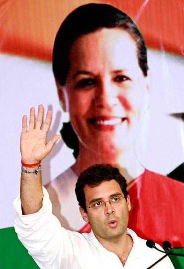 Rahul Gandhi sits in front of a poster of his mother and UPA chief Sonia Gandhi