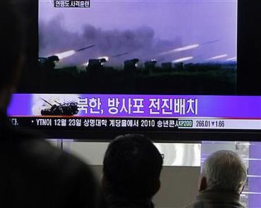 People watch a news report featuring old video footage of a North Korean firing drill, at a railroad station in central Seoul in this December 20 photo