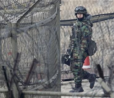 A South Korean Army soldier patrols along the military barbed wire fence near the demilitarised zone separating the two Koreas in Paju, north of Seoul