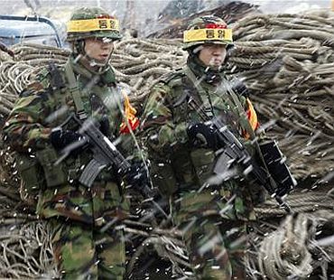 South Korean marines patrol as residents board a ship to leave Yeonpyeong Island, at a port on the island