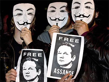 WikiLeaks supporters hold pictures in support of Assange and wear masks of the 'Anonymous' internet activist group during a demonstration in front of the British embassy in Madrid