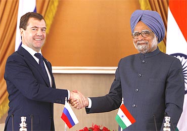 Russia's President Dmitry Medvedev (L) shakes hands with PM Manmohan Singh after signing of agreements ceremony in New Delhi on Tuesday