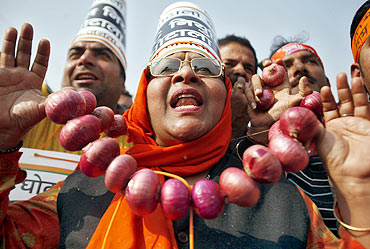 A BJP supporter wears a garland made of onions