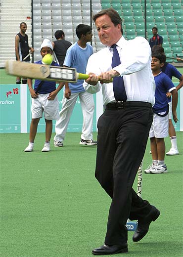 British Prime Minister David Cameron plays cricket inside a stadium in New Delhi