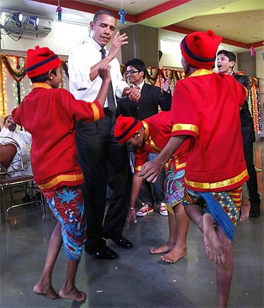 US President Barack Obama dances with children during his visit to the Holy Name High School in Mumbai