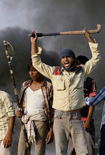 Ethnic Gujjar men shout slogans as they block a national highway during a protest in Sikandra, Rajasthan