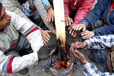 Locals warm themselves as freezing cold grips Kashmir