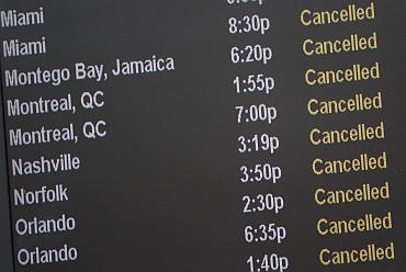 A board lists cancelled flights at JFK International Airport in New York