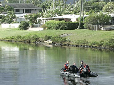 A Coast Guard patrol dingy rides up the canal near the house where US President Barack Obama is staying while he is on Christmas vacation in Kailua, Hawaii